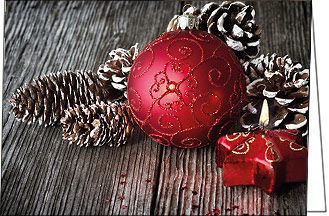 Weihnachtskarte mit roter Weihnachtskugel und Kerze auf Holztisch